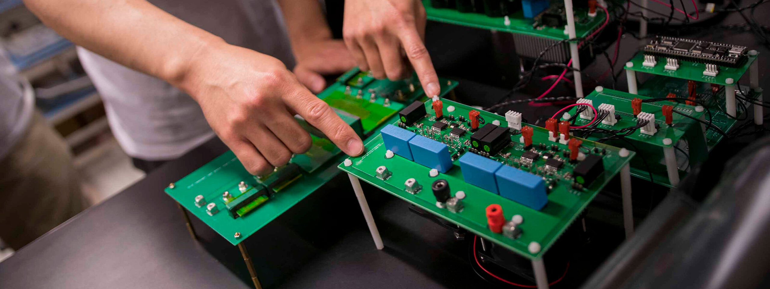 A pair of hands works on semiconductor devices.