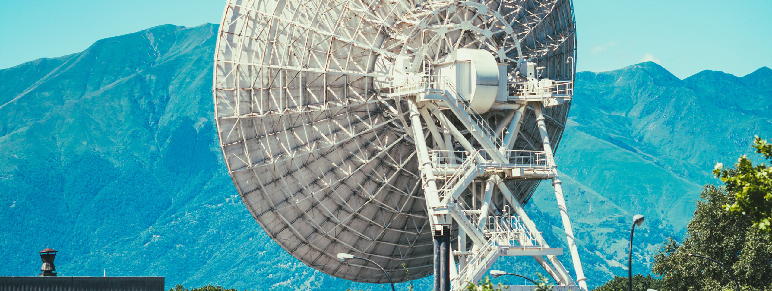 A radar dish in front of mountains