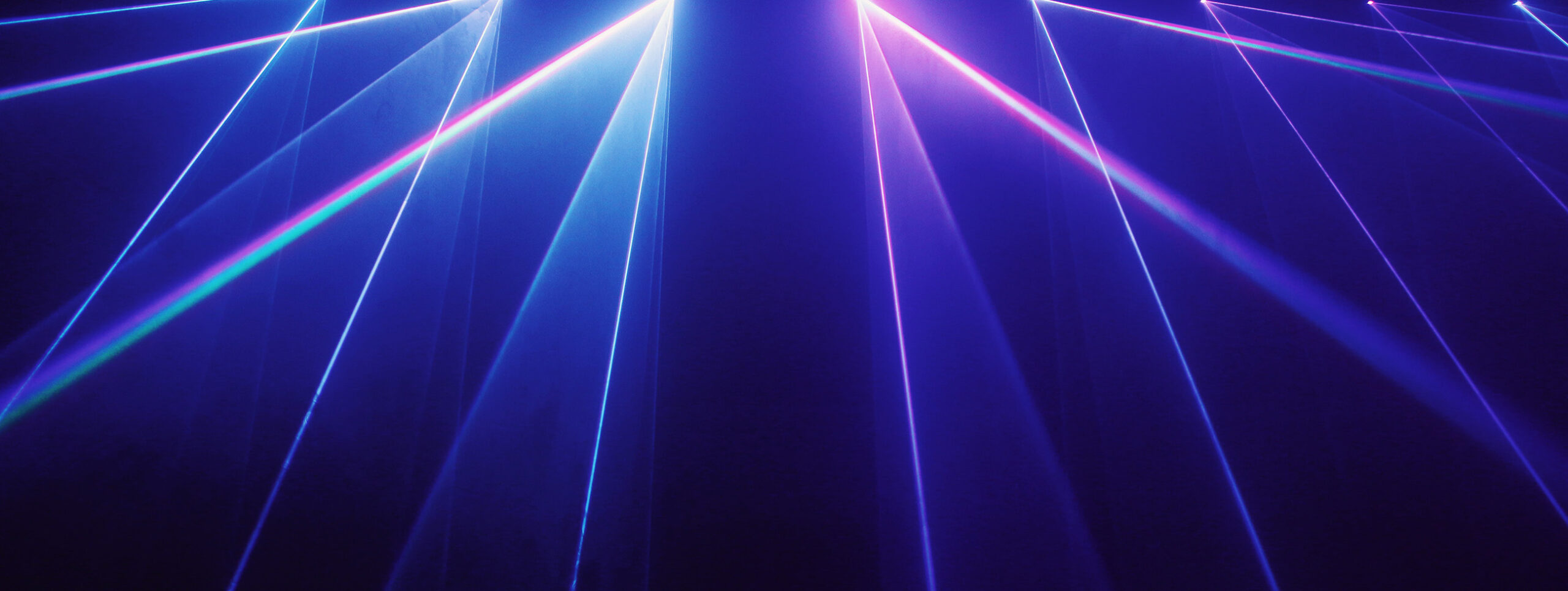 Laser lights in various colors on a blue background