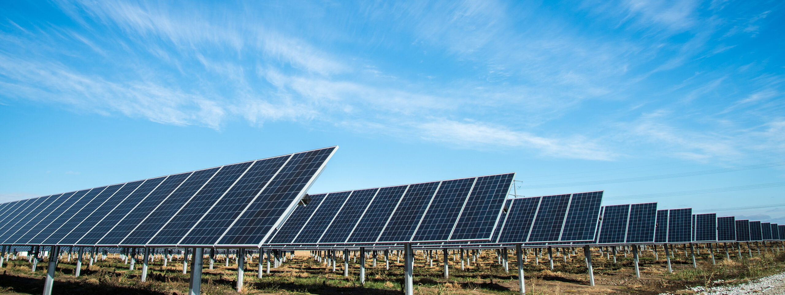An array of solar panels in front of a blue sky