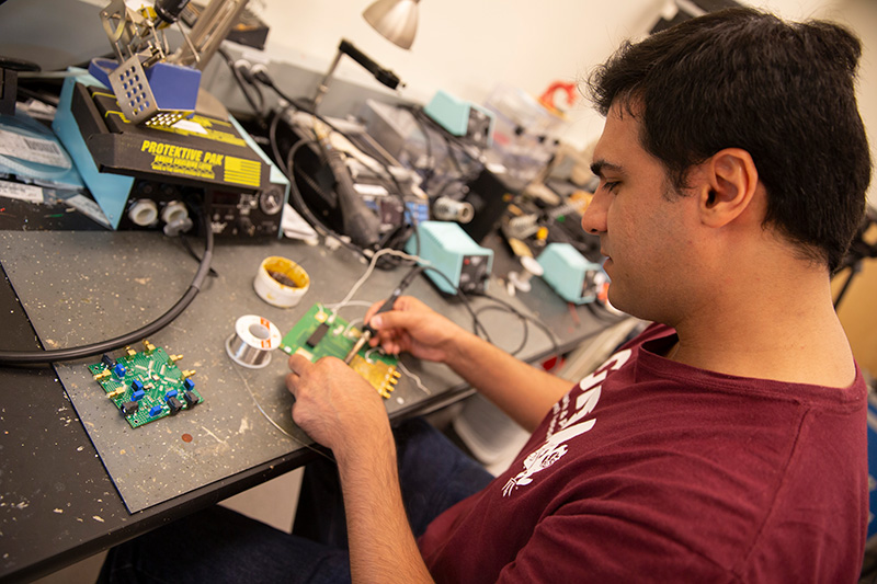 A student solders an integrated circuit device