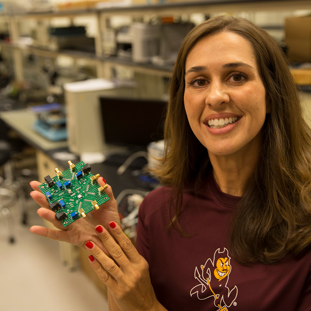 Jennifer Kitchen holds a semiconductor chip up to the camera