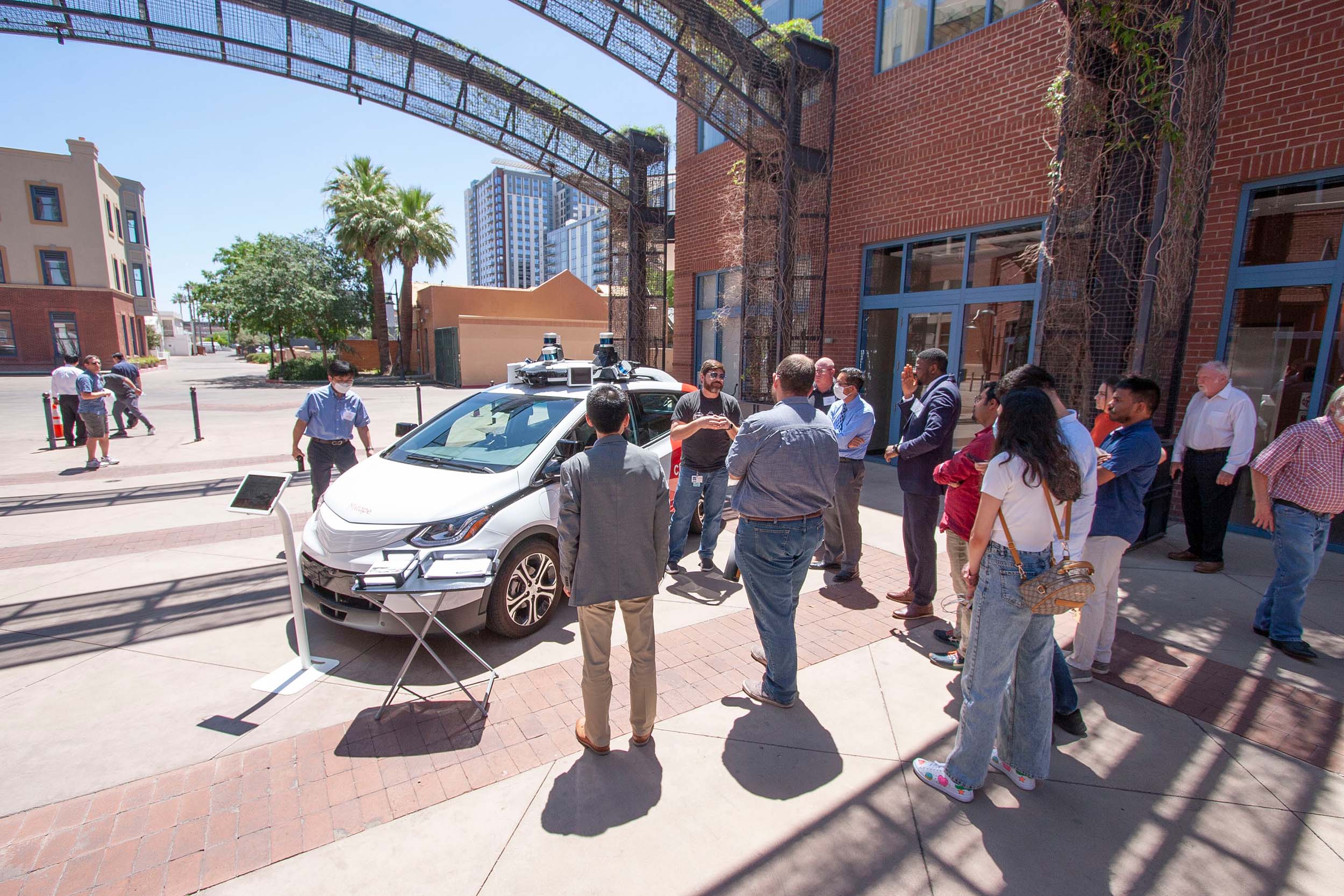 A crowd of people around an electric autonomous vehicle