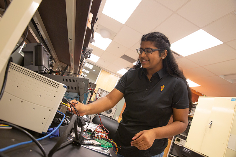 A student works on electrical equipment in a lab