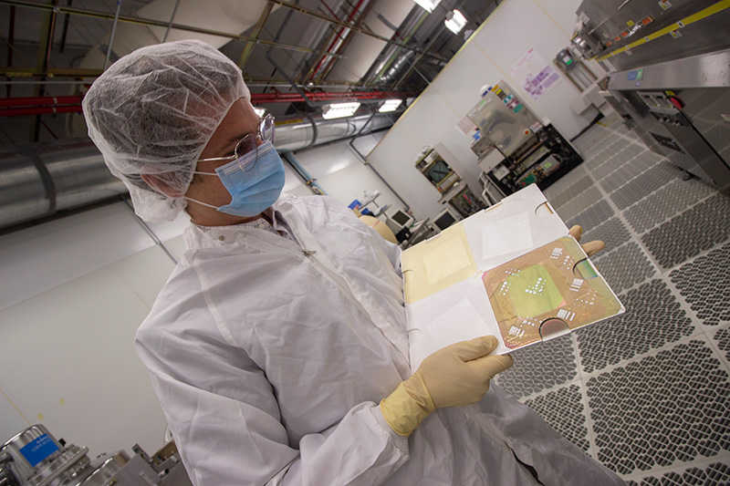 A researcher examines a photovoltaic panel in a lab