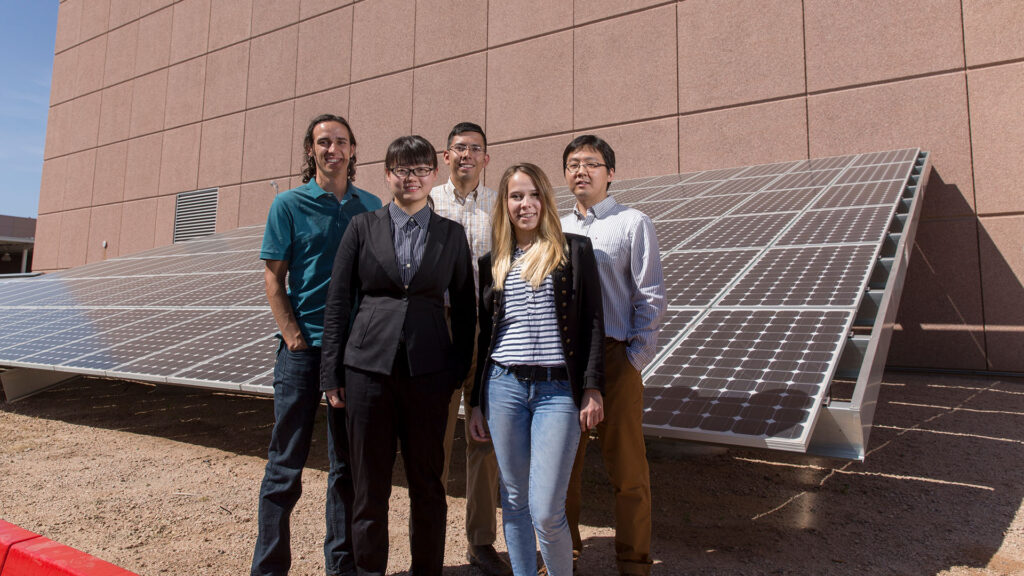 Students stand in front of a solar array at an ASU facility